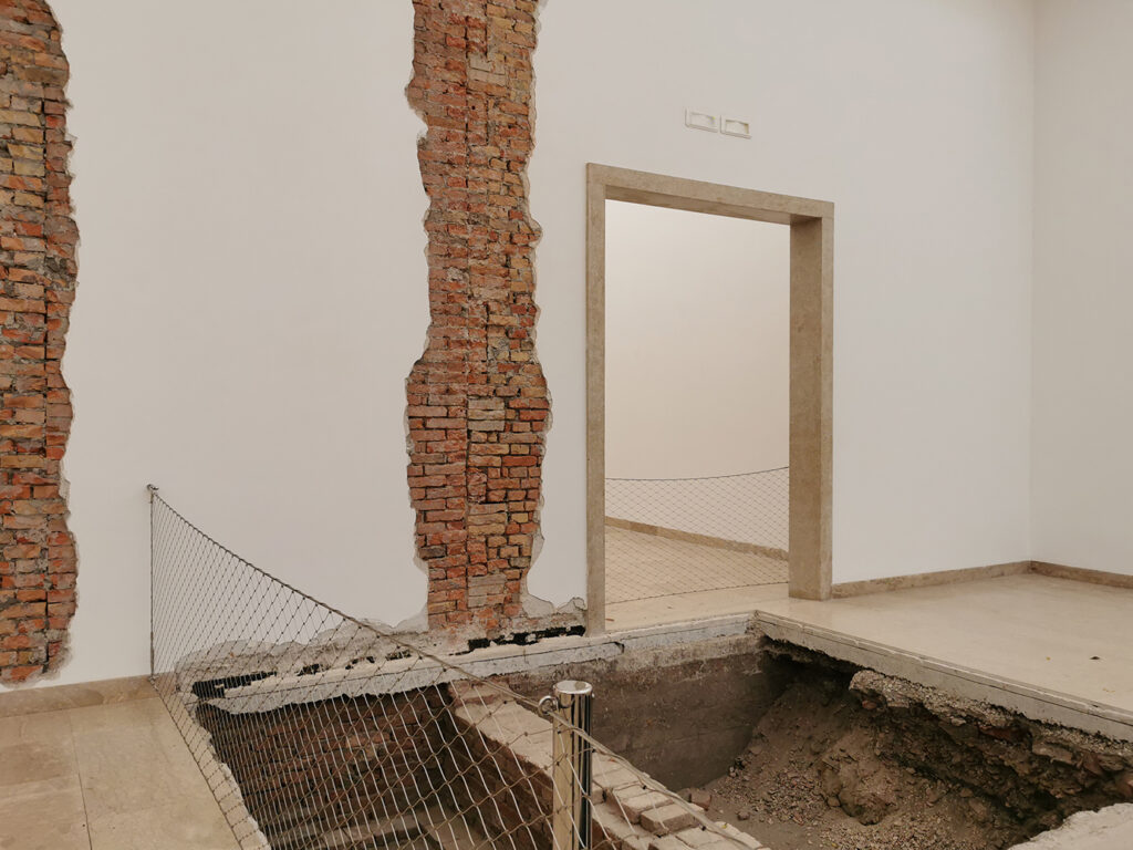 Innenansicht mit teilweise freigelegtem alten Mauaerwerk und offengelegtem Boden im Deutschen Pavillon auf der Biennale in Venedig