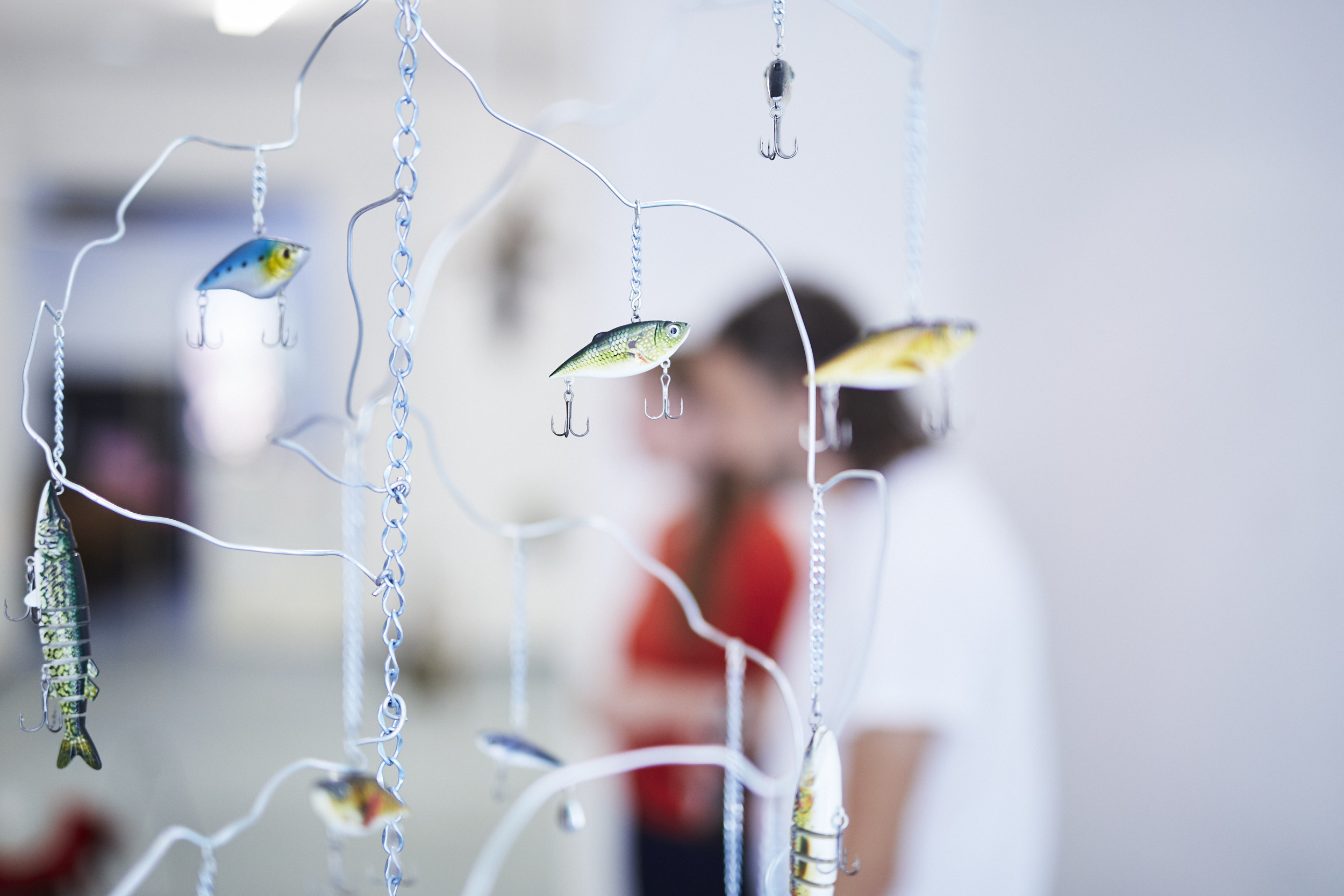 Detailaufnahme eines Mobiles mit Angelhakender Künstlerin Hannah Cooke während einer Ausstellung in Karlsruhe