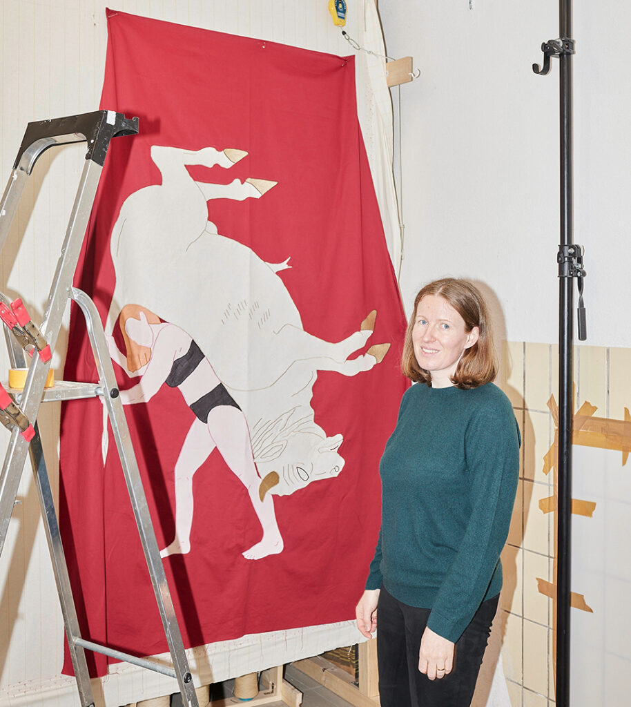Die Künstlerin Hannah Cooke steht im Atelier neben einer ihrer Red Flags anlässlich einer Picasso Ausstellung