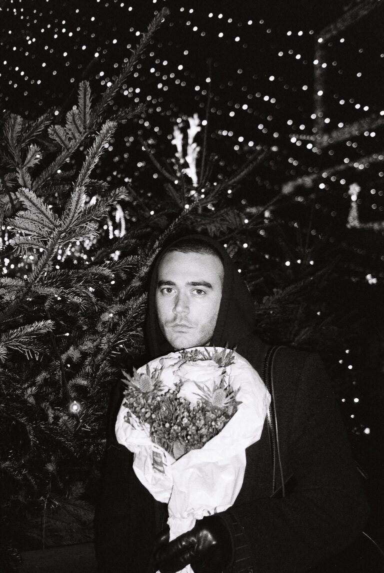 Das Bild zeigt Jonathan Guggenberger mit einem Blumenstrauß in der Hand.