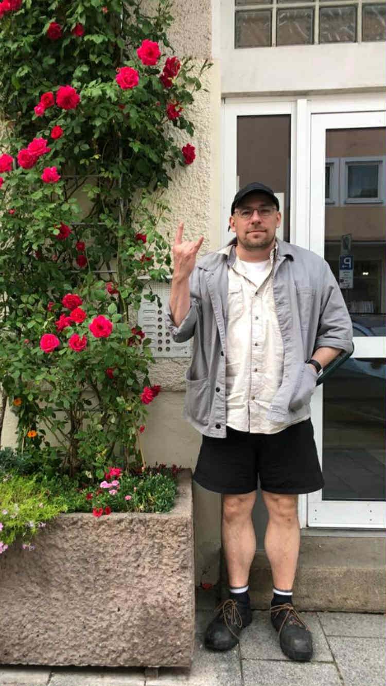 Das Bild zeigt Jeffrey Grunthaner neben einer Rosenranke.